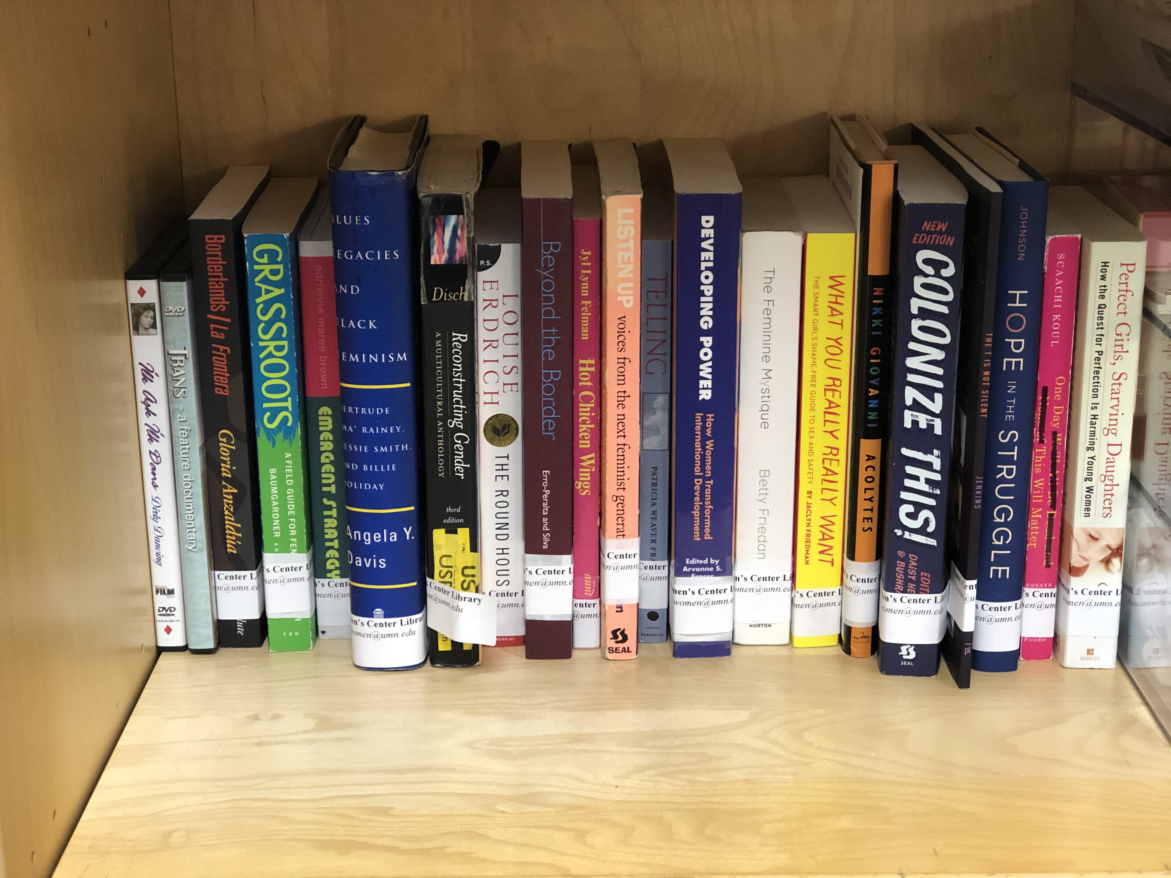 A row of books on a shelf in the Women's Center Library.